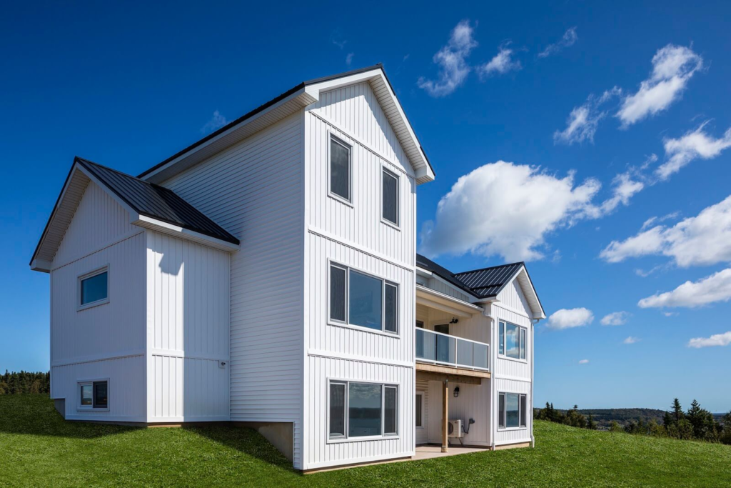 Front left view of a large white home and green lawn